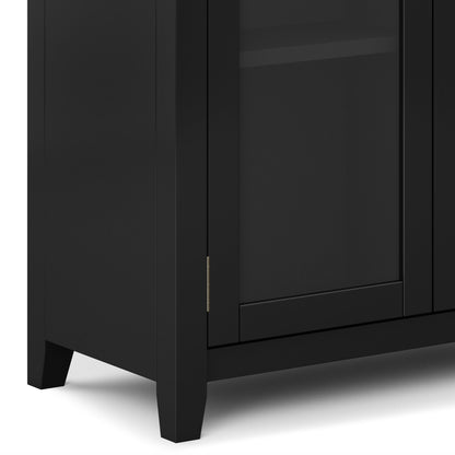 Close-up of the bottom corner of the Cosmopolitan - Handcrafted Medium Storage Cabinet in black, featuring a glass-panel door with visible hinge and short tapered legs.