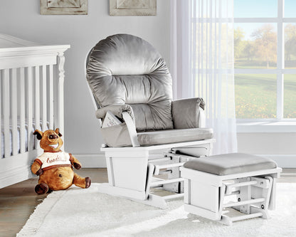 A cozy nursery includes the Madison Glider & Ottoman with a white base, a white crib, a plush brown dog toy in a "Goodies" shirt, and sunlight streaming through sheer curtains on a large window.