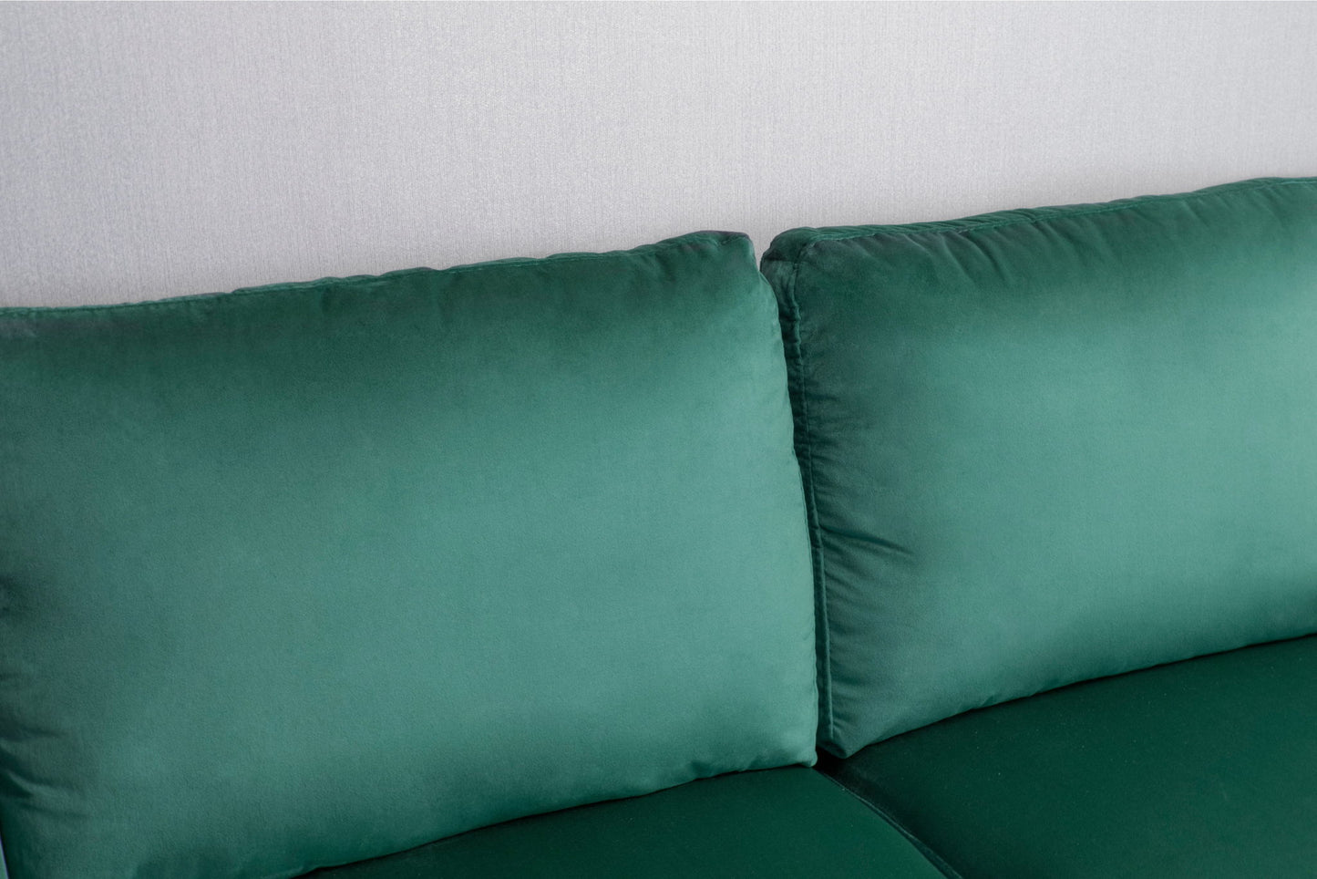 Close-up of the backrest and seat cushions of the Comfortable Loveseat With Durable Construction in green velvet, set against a light gray wall. The soft upholstery and plush cushions offer a modern, inviting appearance.