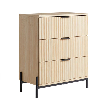 The Mid-Century 3 Drawer Chest With Reeded Drawer Fronts features a light wood finish, three drawers with vertical grooves and black rectangular handles, and stands on black metal legs with an open frame base.