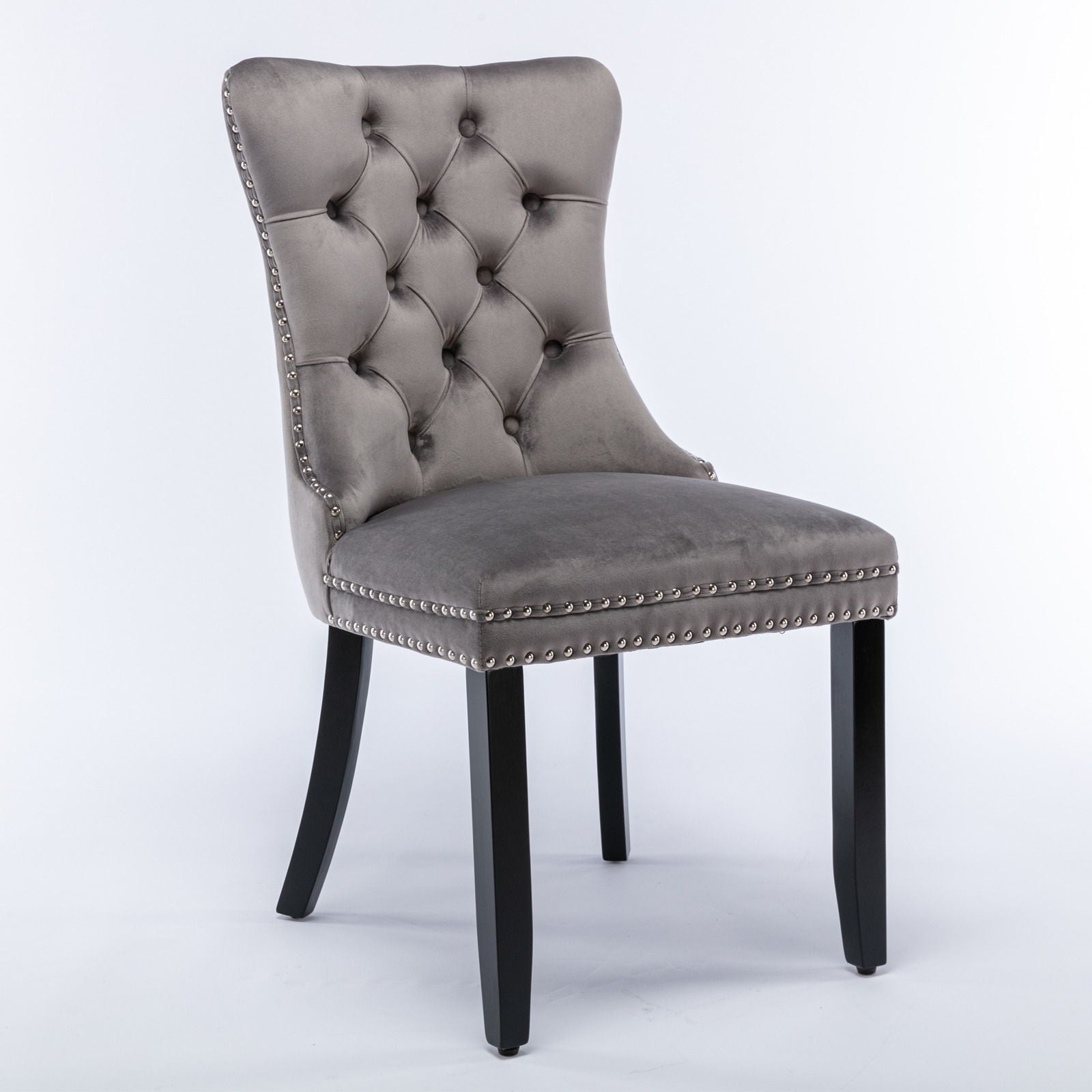 The Nikki set includes two modern, high-end dining chairs with tufted velvet upholstery, nailhead trim, and solid wood legs, shown here in gray against a white background.