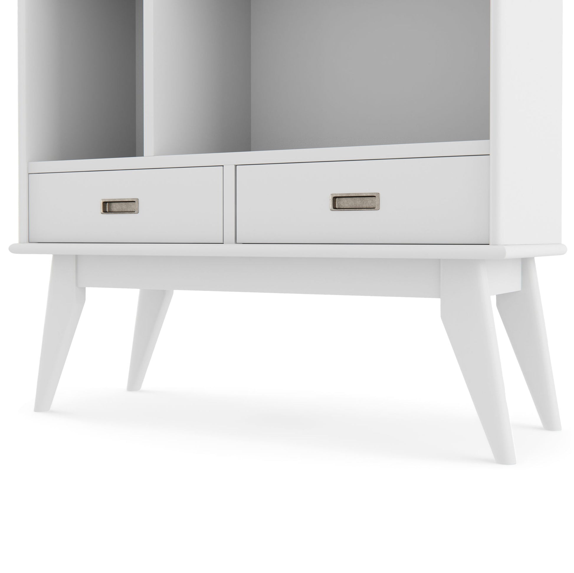A close-up of the Draper - Mid Century Wide Bookcase And Storage Unit, a modern white cabinet with two drawers, metal label handles, four angled legs, and an open shelf space above the drawers.