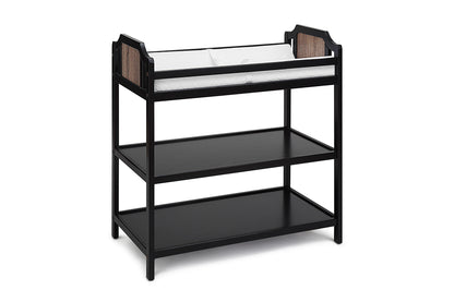 The Brees - Changing Table features a black wooden design, two open storage shelves, and a white cushioned changing pad on top.