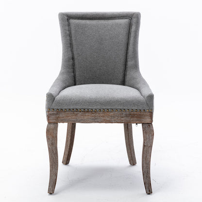 Ultra Side Dining Chair set of 2 features thickened gray fabric, neutrally toned solid wood legs, and bronze nailhead trim along the seat edge, shown against a plain white background.