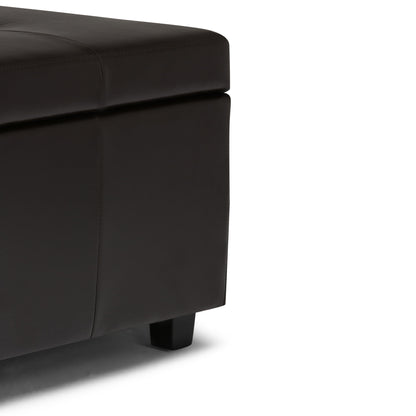 Close-up view of the Castleford - Contemporary Storage Ottoman, featuring dark brown leather upholstery, short black legs, and visible stitching details.