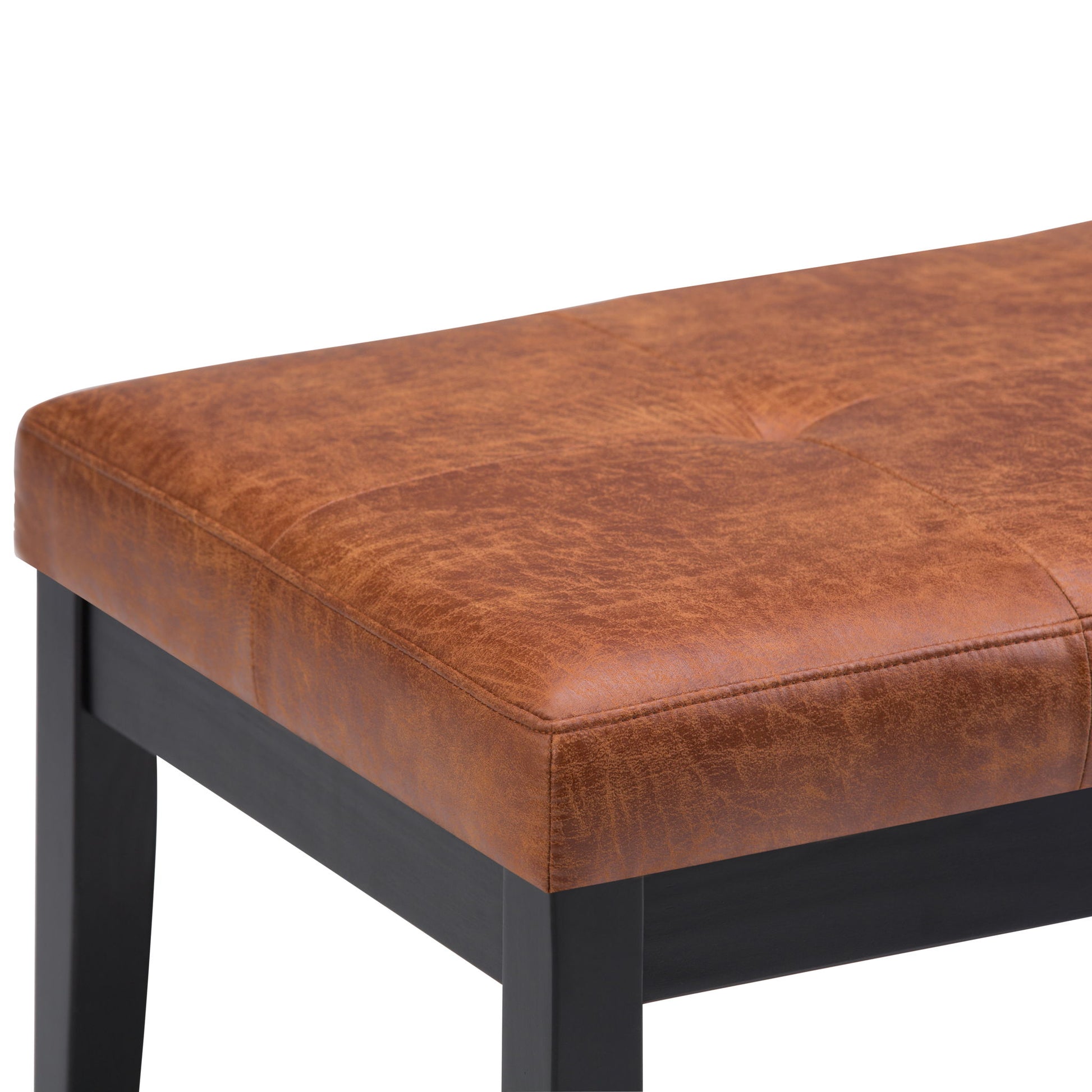 A close-up of the Lacey - Upholstered Tufted Ottoman Bench featuring a brown faux leather cushioned seat with visible stitching, tufted details, and black wooden legs.