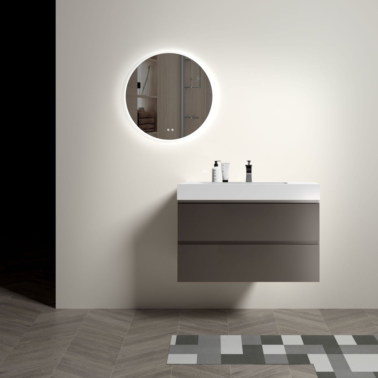 Minimalist bathroom featuring the Alice wall mounted floating vanity with a one-piece sink basin, white countertop, soap dispensers, and a round backlit mirror on a plain wall. Modern geometric floor tiles appear in the foreground.