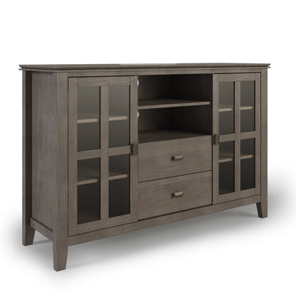 The Artisan Handcrafted Tall TV Media Stand features a gray wood finish, two glass-paneled cabinet doors on each side, two center open shelves, and two pull-out drawers beneath the shelves.