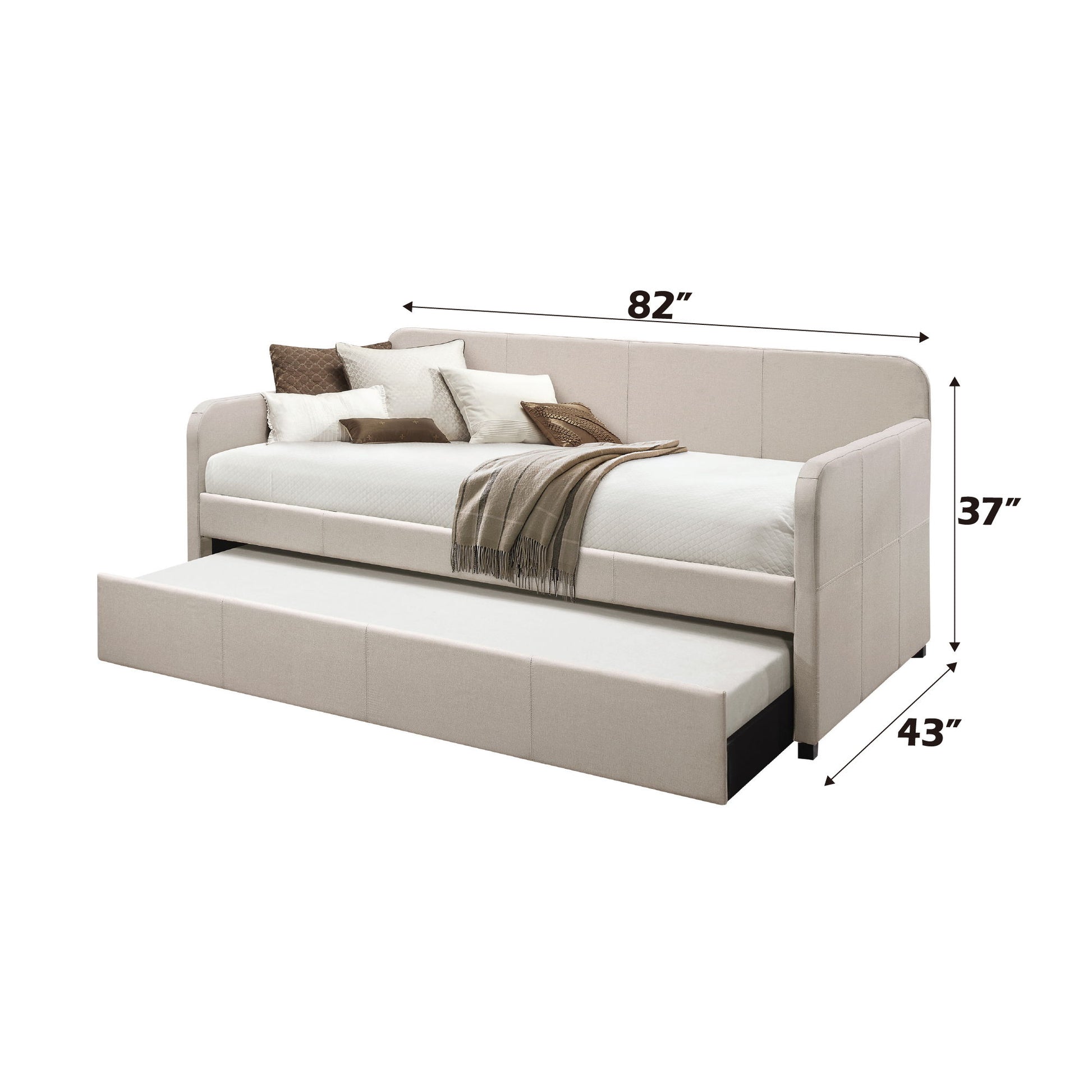 The Jagger - Twin Daybed With Trundle in Fog features a beige upholstered design, includes a pull-out trundle, and measures 82"L x 43"D x 37"H. Shown styled with pillows and a brown throw blanket.