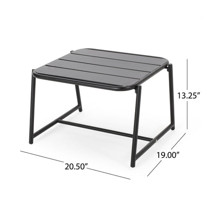 The Conrad Side Table Outdoor is a black metal table with a slatted top, measuring 20.5"W x 19"D x 13.25"H. Featuring a minimalist design, it includes straight legs and a support bar near the base—perfect for outdoor settings.