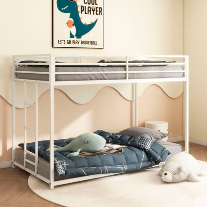 A children's bedroom features the Adam - Metal Bunk Bed in white; the top bunk has gray bedding, and the lower bunk has a blue comforter. A plush whale sits on the bed, a stuffed bear is on the floor, and a dinosaur basketball poster decorates the wall.