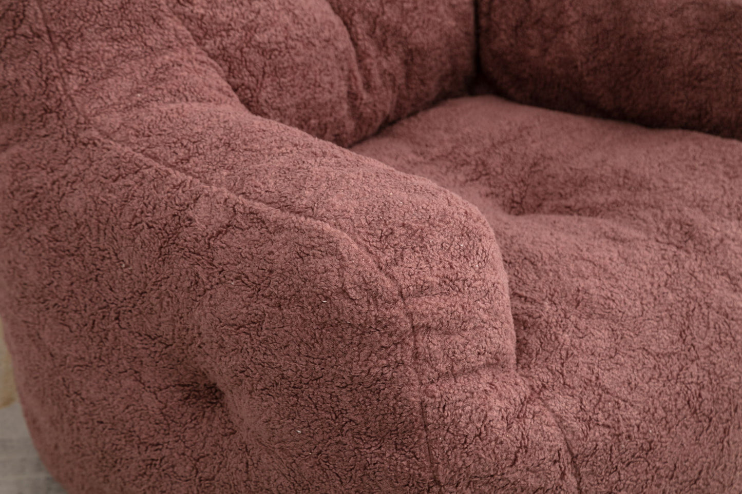 Close-up of the Soft Teddy Fabric Tufted Foam Bean Bag Chair, upholstered in plush, mauve teddy fabric with a cozy, textured look. Features a deep seat and cushioned armrest for extra comfort.