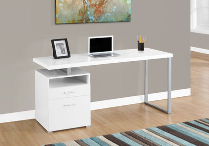 The Computer Desk For Home Office features metal legs, two storage drawers, and a shelf. It holds a laptop, framed photo, and pencil cup. Placed on wooden flooring near a gray wall with artwork above, it stands by a striped rug.