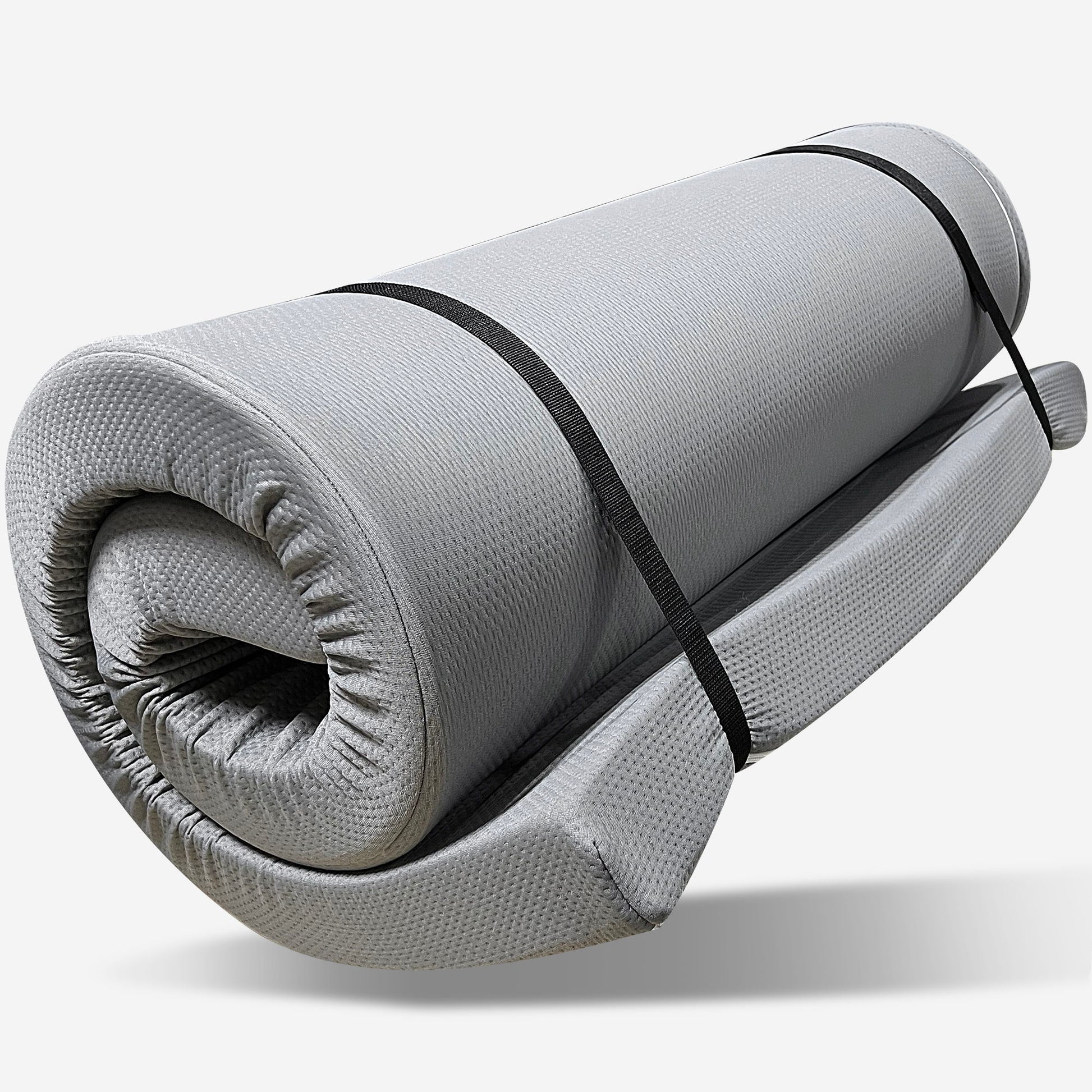 The Memory Foam Camping Mattress Foldable in gray is shown rolled up, secured with two black straps, against a plain white background. Portable and water resistant, it’s ideal for camping or travel.