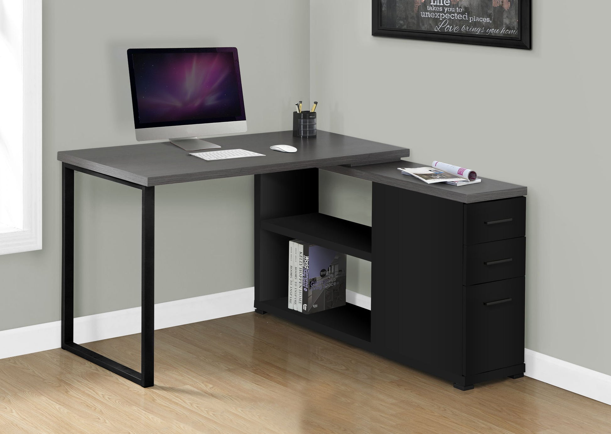 A contemporary L-shaped Computer Desk for home office with left/right setup, storage drawers, open shelves for books, and space for a laptop, set against a light gray wall on a wooden floor.
