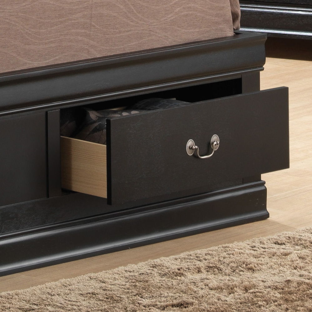 A close-up of the Louis Phillipe - Bookcase Storage Bed shows its dark wood frame with an open storage drawer beneath holding clothes. The bed rests on a light wood floor, with part of a beige rug visible in the foreground.
