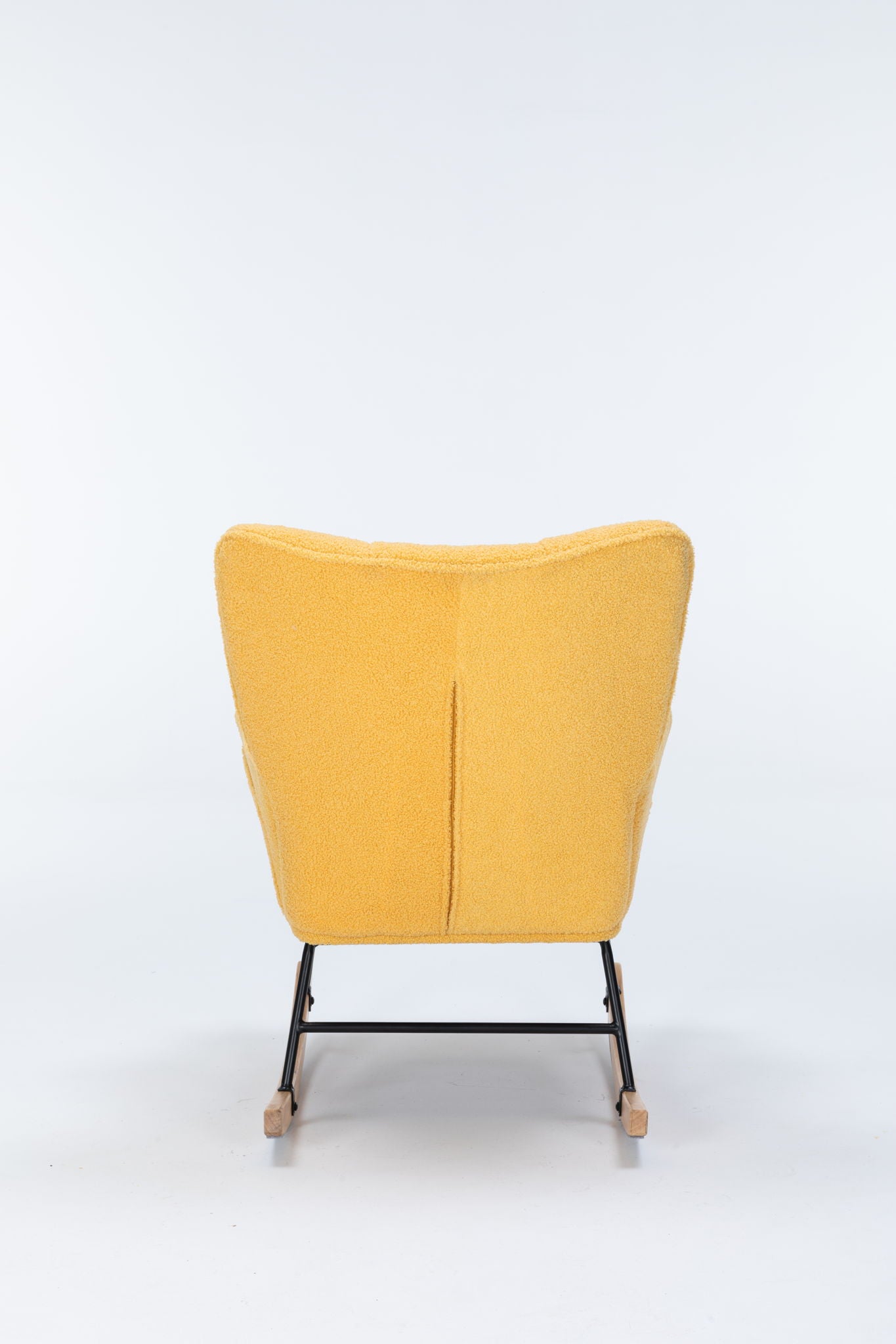 The Rocking Chair Nursery is a yellow upholstered glider rocker with a high curved backrest, black metal legs, and wooden rockers, shown from behind on a plain white background.