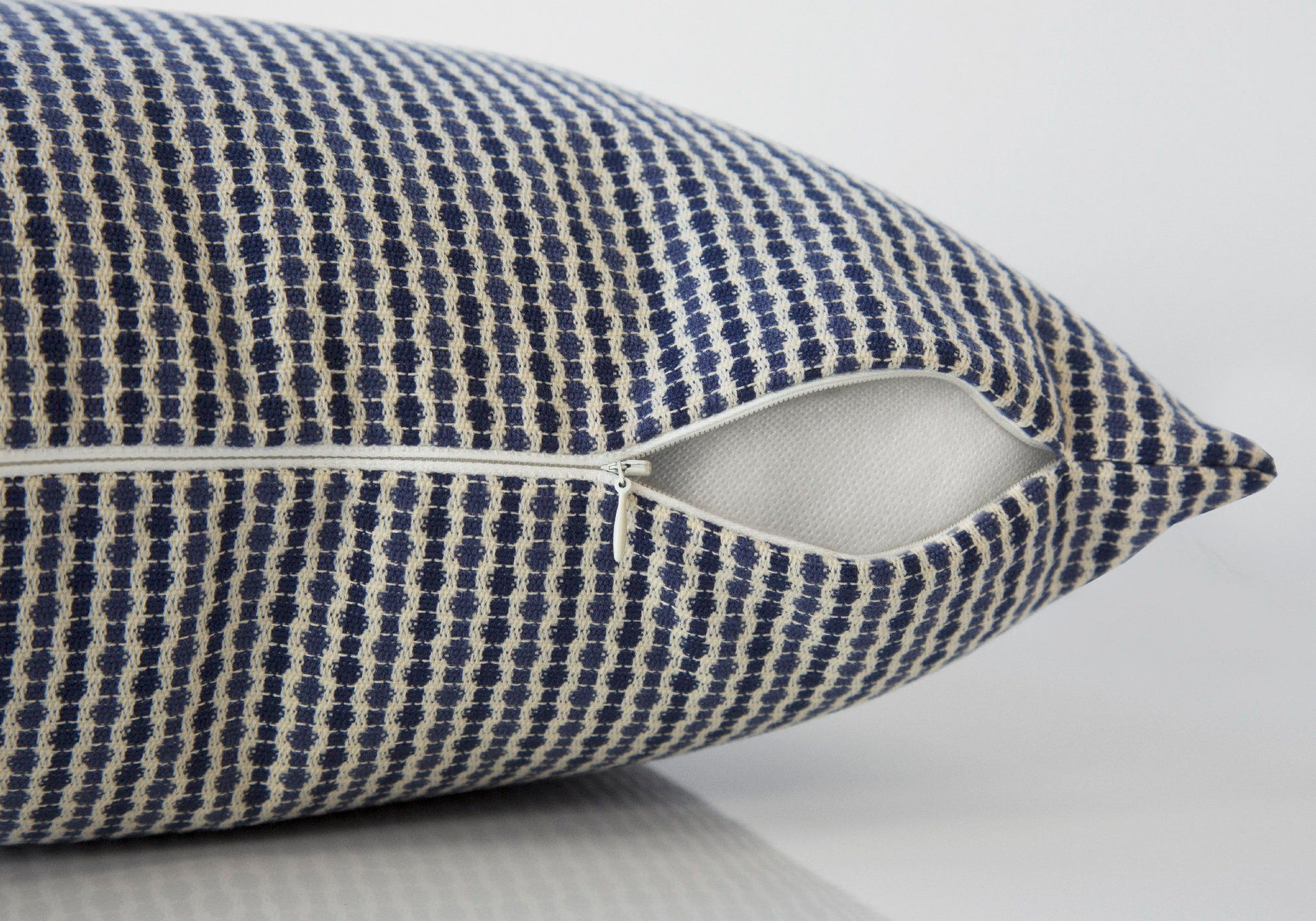 Close-up of the Square Decorative Throw Pillow, blue and white patterned, with a partially open white zipper showing the hypoallergenic insert. The background is plain and light-colored. Insert included.