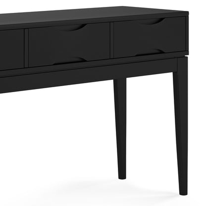 A close-up view of the Harper - Handcrafted Console Sofa Table, a modern black wooden desk with four drawers and tapered legs, highlighting its left side and two front legs.