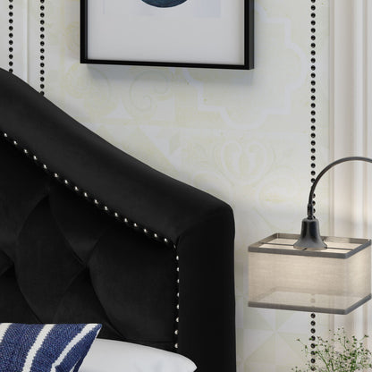 A close-up of the Kaarina - Contemporary Tufted Fabric Headboard in black with silver studs, beside a floating nightstand with a modern lamp, a white and blue pillow, subtle patterned wallpaper, and framed wall art above.