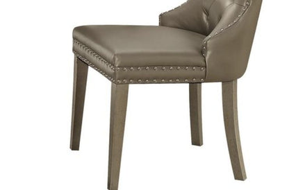 The Kacela Synthetic Leather Side Chair (Set of 2) in Champagne features a modern design with a sleek upholstered seat and backrest, decorative accents, and sturdy wooden legs.