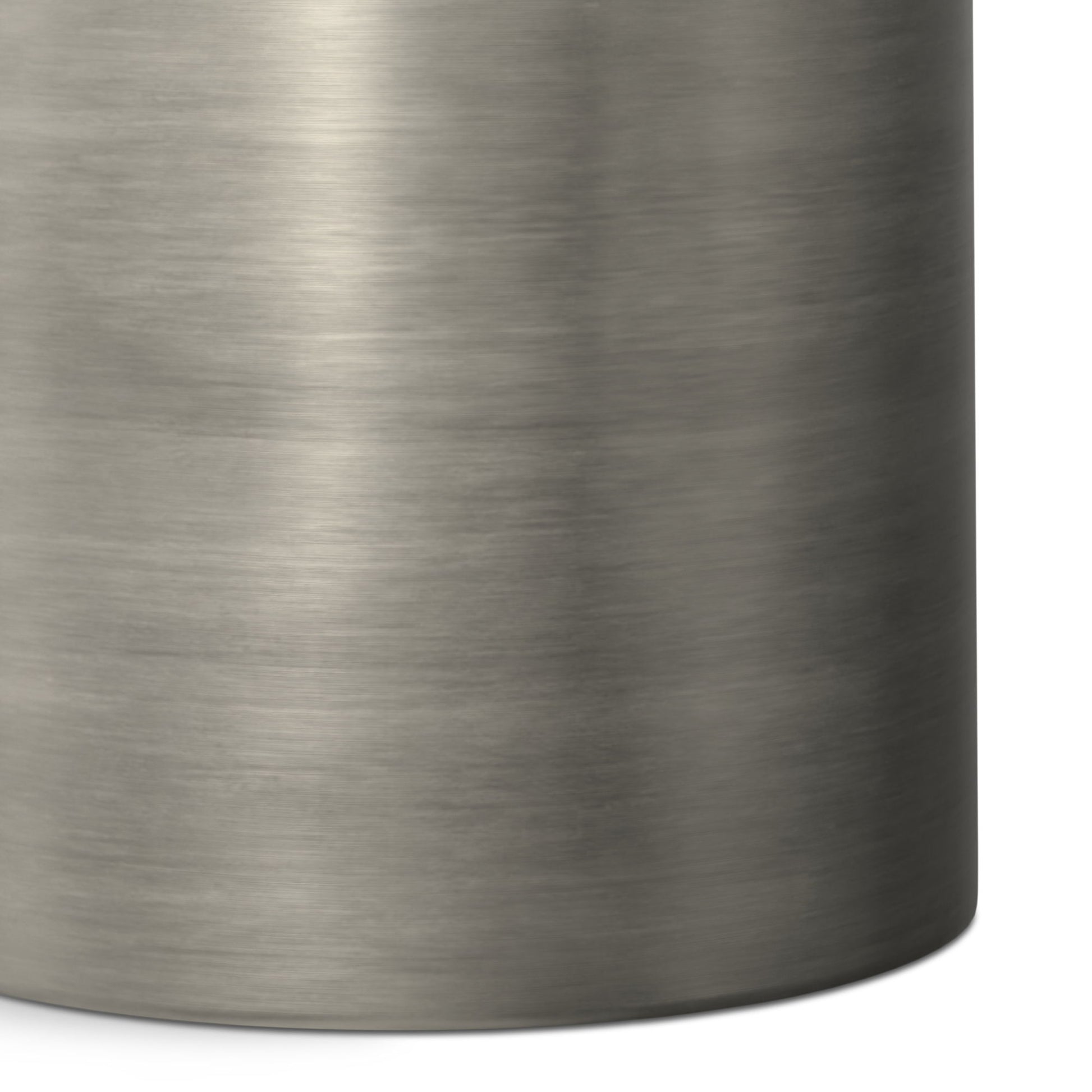 Close-up of the Corbin Handcrafted Metal Side Table in brushed stainless steel, highlighting its smooth metallic texture and rounded right edge.