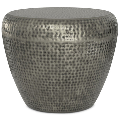 The Preston Handcrafted Metal Side Table features a round, silver-toned design with a hammered finish and a subtly tapered base, offering a modern, industrial look.