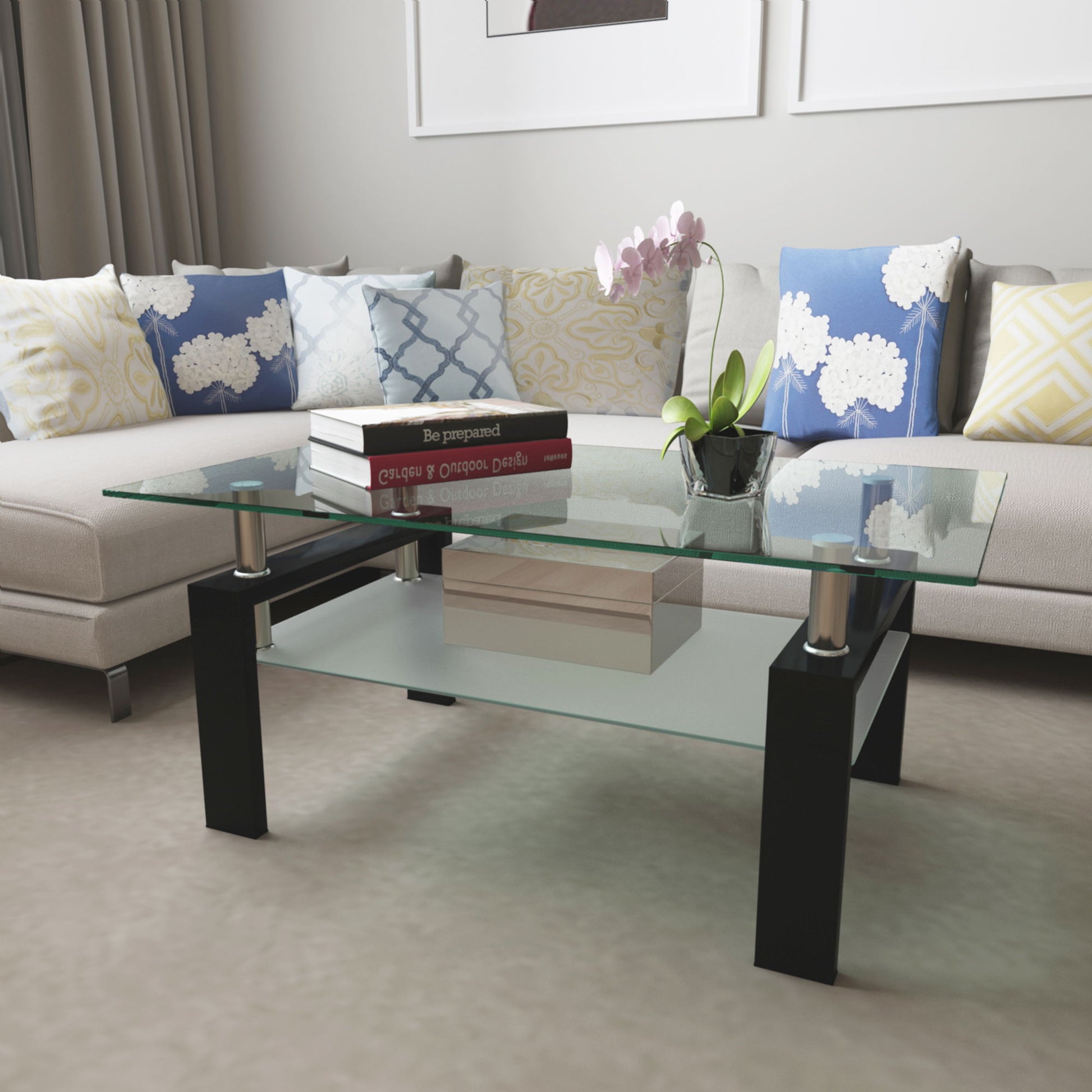 A modern living room featuring the Modern Rectangular Coffee Table With Tempered Glass Top, which holds books and a potted orchid, placed before a light sectional sofa with patterned blue, yellow, and white cushions.