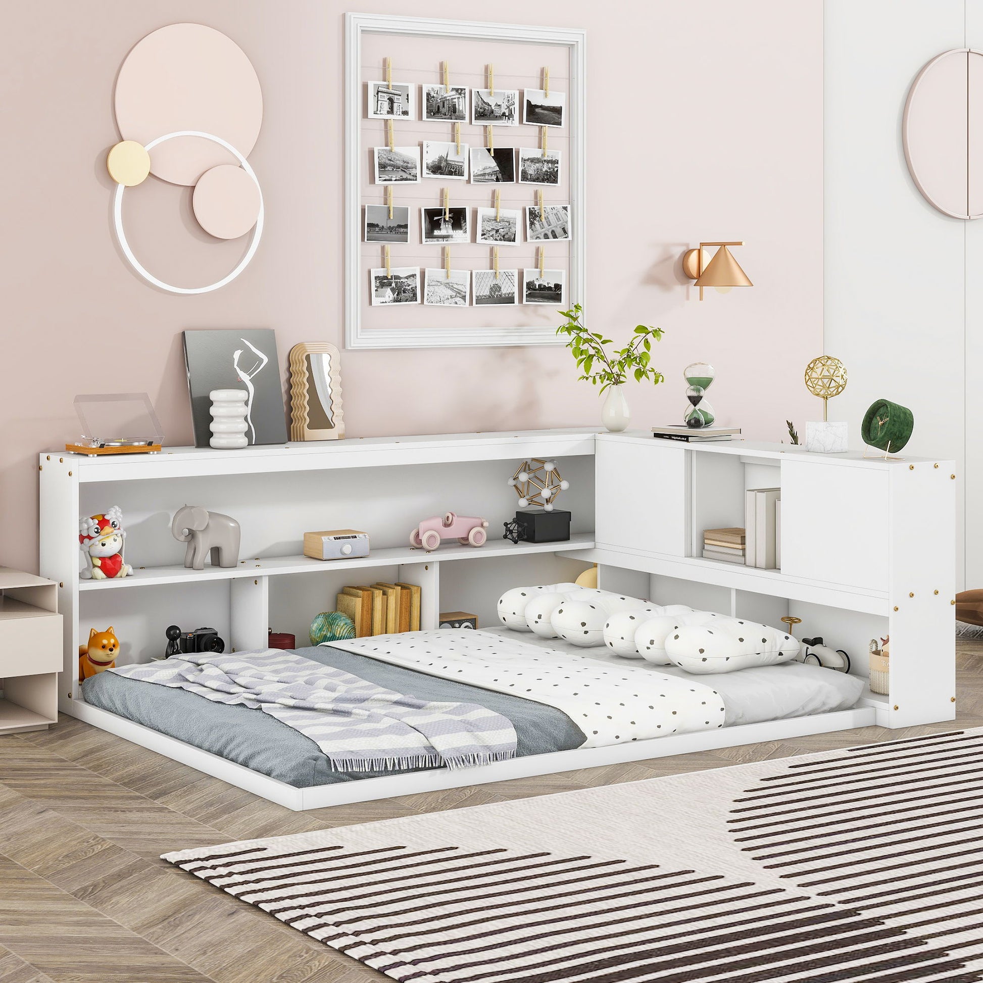 A cozy children's bedroom features a Floor Bed With L-Shaped Bookcases, Sliding Doors, Without Slats, filled with toys and books, accented by pastel wall art, a photo collage, soft lighting, and a patterned rug.