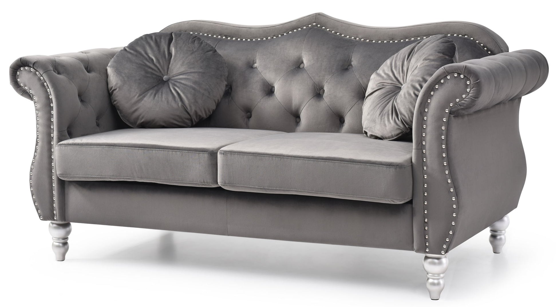 The Stylish Flared Arm Loveseat features gray tufted velvet upholstery, silver studs, rolled arms, two round matching pillows, and white turned wooden legs.