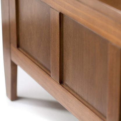 Close-up of the Brooklyn Entryway Storage Bench in Medium Saddle Brown, showcasing its smooth finish, paneled detailing, clean lines, and sturdy legs.