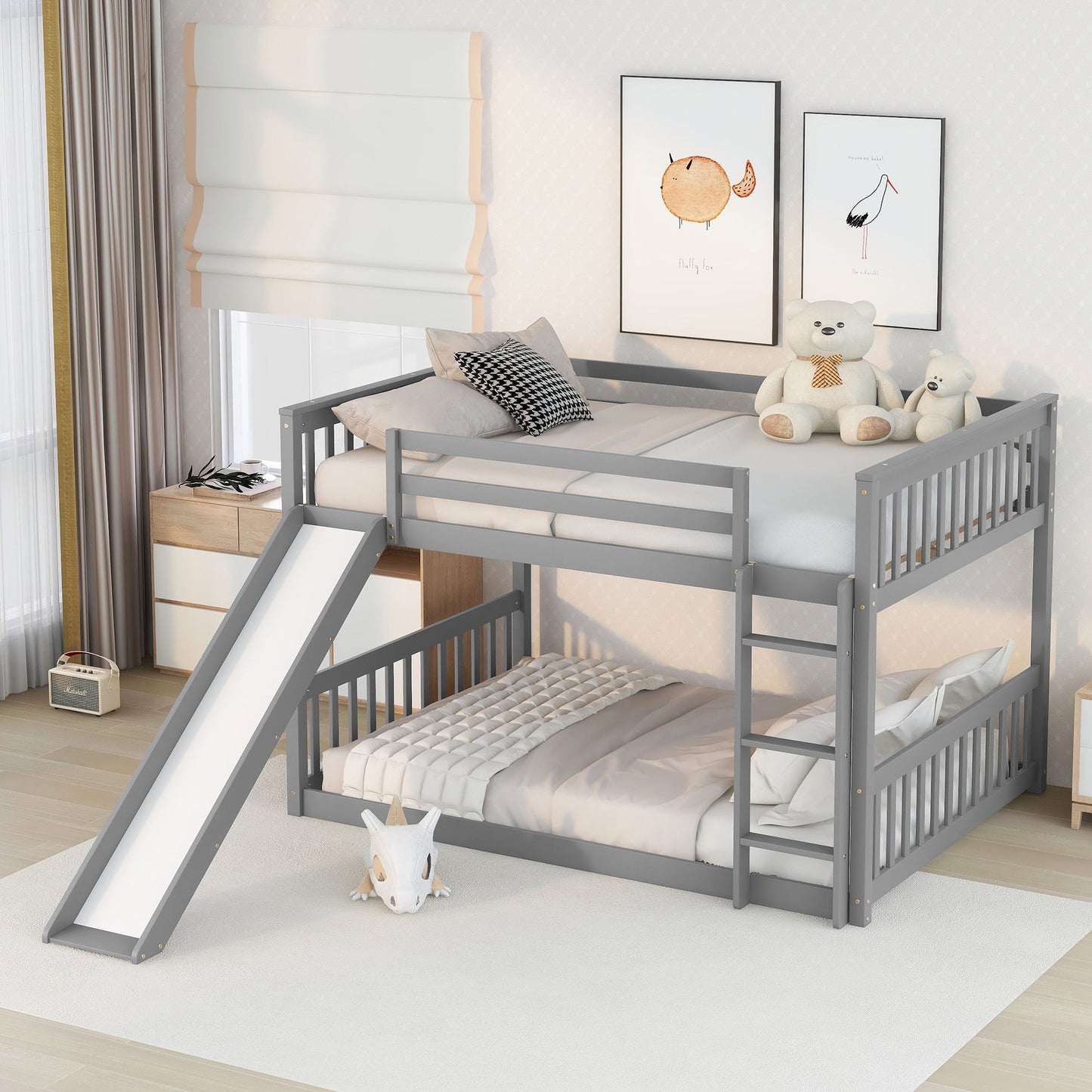 A children's bedroom features the Bunk Bed With Slide And Ladder in gray; stuffed animals and a pillow are on the top bunk, the bottom bunk is neatly made, and a slide descends beside a small plush toy on the floor.