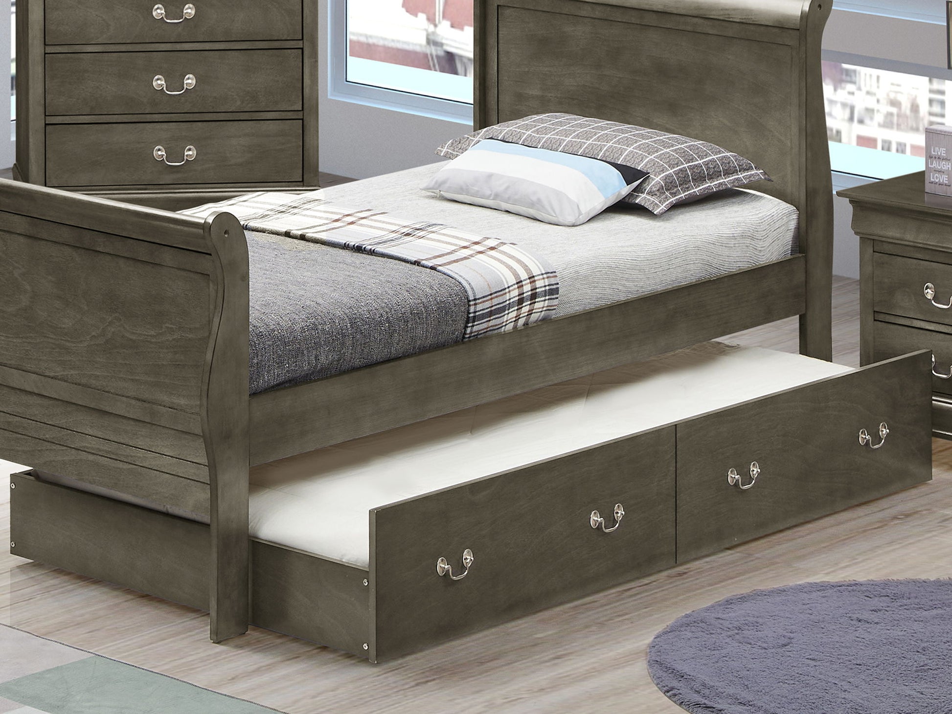 The Elegant Trundle Bed With Timeless Charm features a wooden frame, plaid blanket, checkered pillow, pull-out trundle with two drawers, and sits in a modern bedroom with large windows.