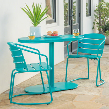A 3 Piece Elegant Outdoor Bistro Set with 2 chairs and an oval table is displayed on a stone patio beside a white building, the table set with two glasses of white wine, pastries, and a potted plant.