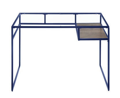 The Yasin Glass Top Writing Desk features a minimalist design with a blue metal frame and a right-side wooden shelf, shown from the front against a white background.