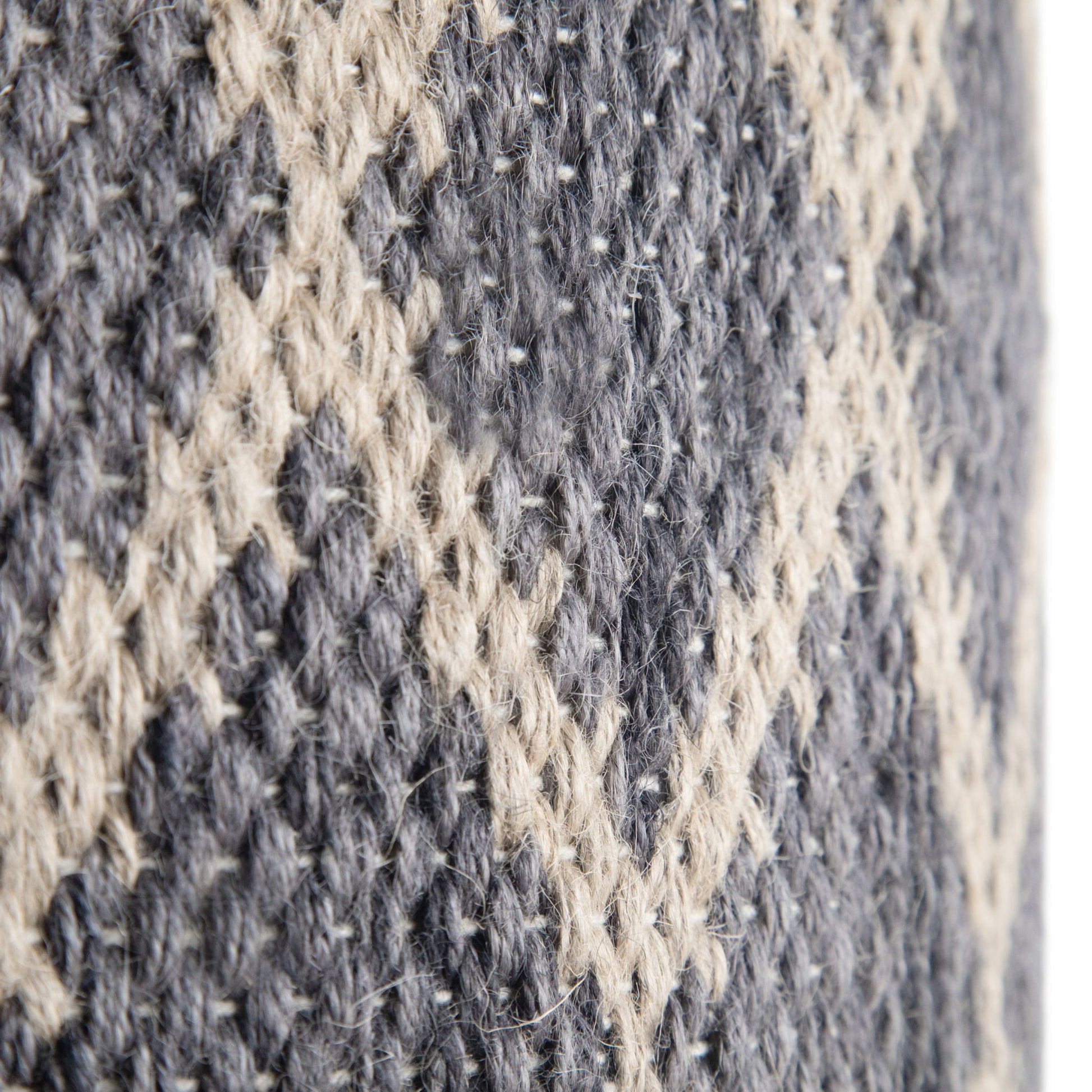 Close-up of the Edgeley - Handcrafted Round Pouf, showing its gray and beige knitted fabric with a raised diamond pattern and textured yarns.