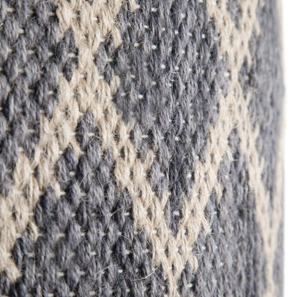 Close-up of the Edgeley - Handcrafted Round Pouf, showing its gray and beige knitted fabric with a raised diamond pattern and textured yarns.