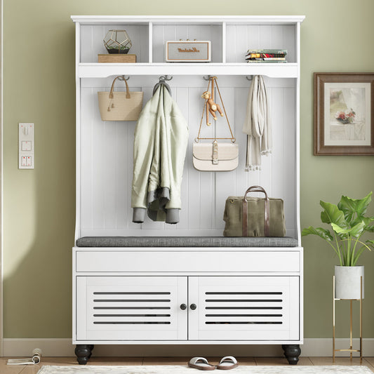 The 5 In 1 Entryway Bench features a cushioned seat, shutter-shaped doors, 4 sturdy hooks for bags and coats, open shelves above, and is set against a light green wall with decor items and a plant nearby.