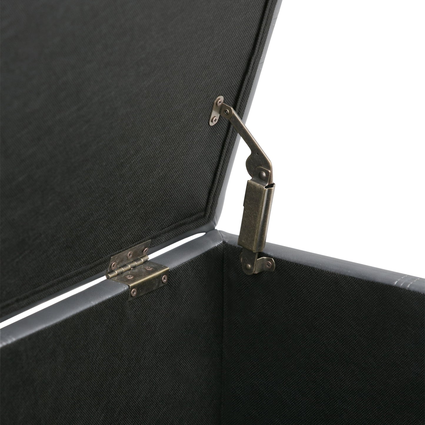 A close-up of the Amelia - Transitional Storage Ottoman Bench's interior corner reveals the metal hinge mechanism securely attached to its fabric-lined lid.