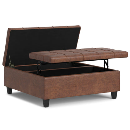 The Harrison Upholstered Coffee Table Storage Ottoman features a brown finish, lift-top lid with interior storage, short black legs, and a stitched square cushion pattern.