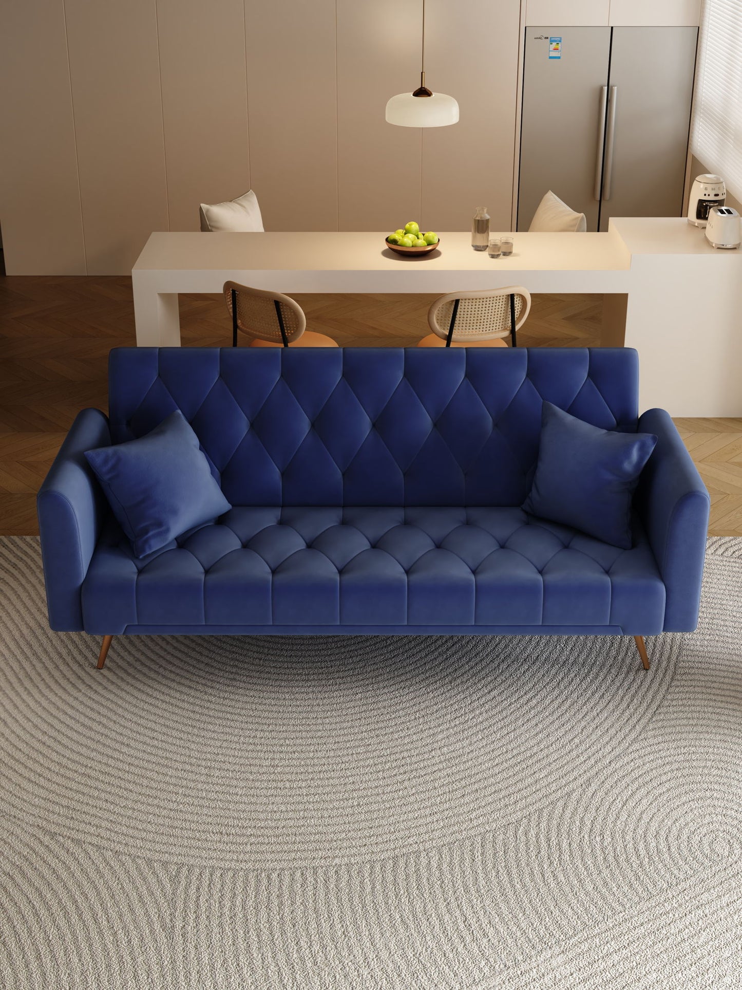 A modern living space features a Convertible Double Folding Living Room Sofa Bed in blue with two matching cushions on a circular rug. In the background are a dining table with chairs, green apples in a bowl, and a refrigerator.