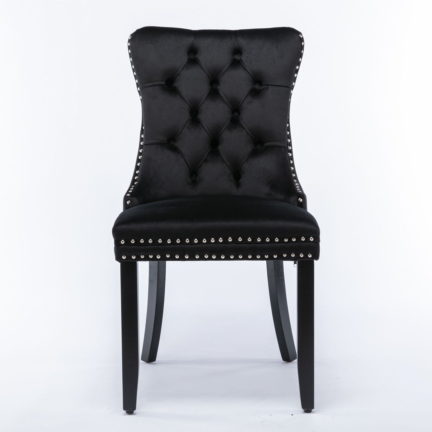 The Nikki is a modern black velvet dining chair with a high, curved, button-tufted back, silver nailhead trim, and four black solid wood legs. Set of 2 contemporary upholstered chairs.