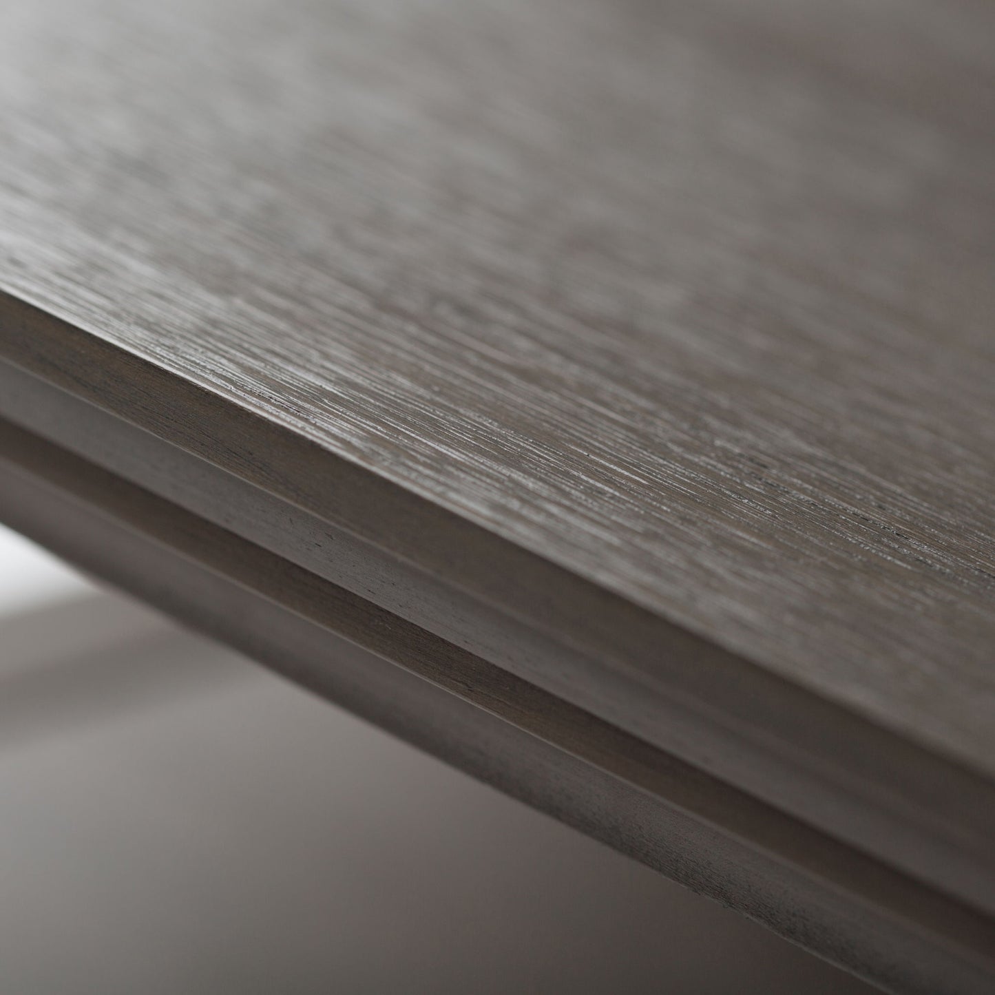 Close-up view of the edge of the Acadian - Handcrafted End Table, highlighting its natural wood grain, fine horizontal lines, and smooth matte finish; softly blurred background.