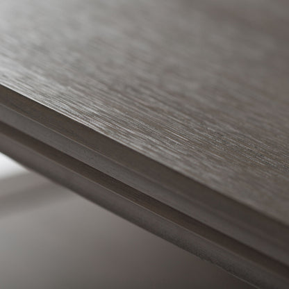 Close-up view of the edge of the Acadian - Handcrafted End Table, highlighting its natural wood grain, fine horizontal lines, and smooth matte finish; softly blurred background.