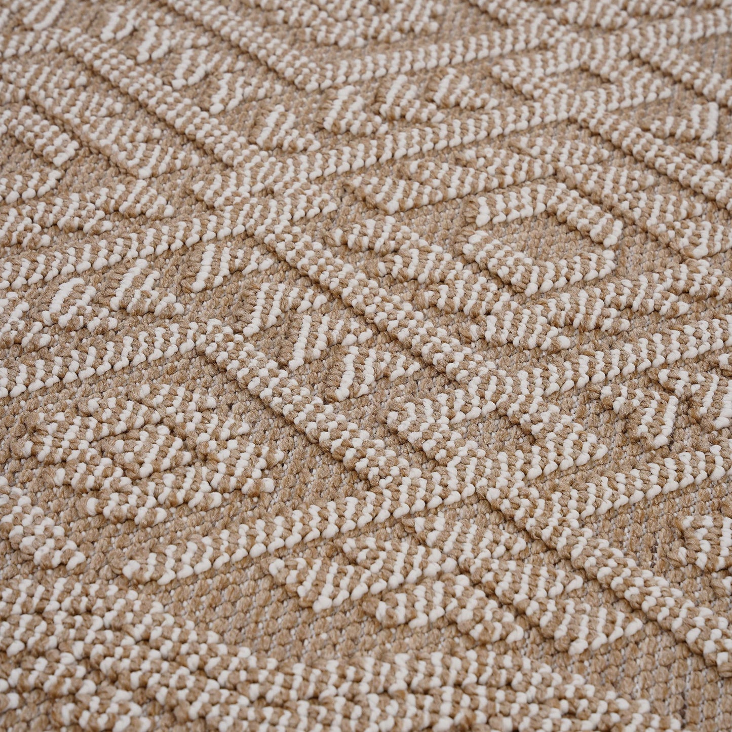 A close-up of the Guros - Traditional Indoor / Outdoor Area Rug, featuring a raised white geometric pattern on a beige background, showcases its textured, visually intricate design.