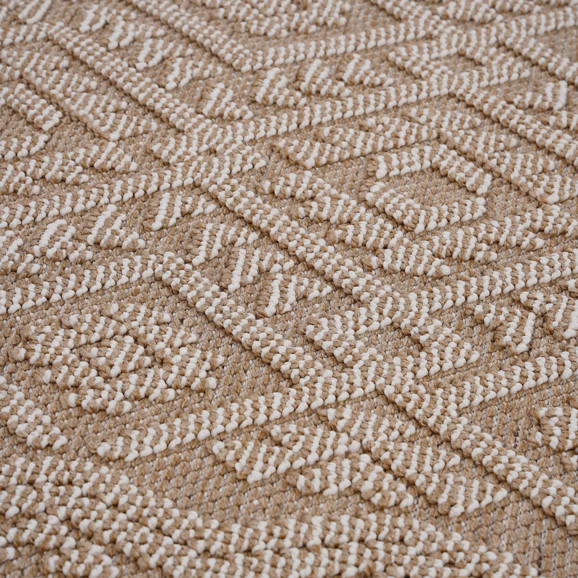 A close-up of the Guros - Traditional Indoor / Outdoor Area Rug, featuring a raised white geometric pattern on a beige background, showcases its textured, visually intricate design.