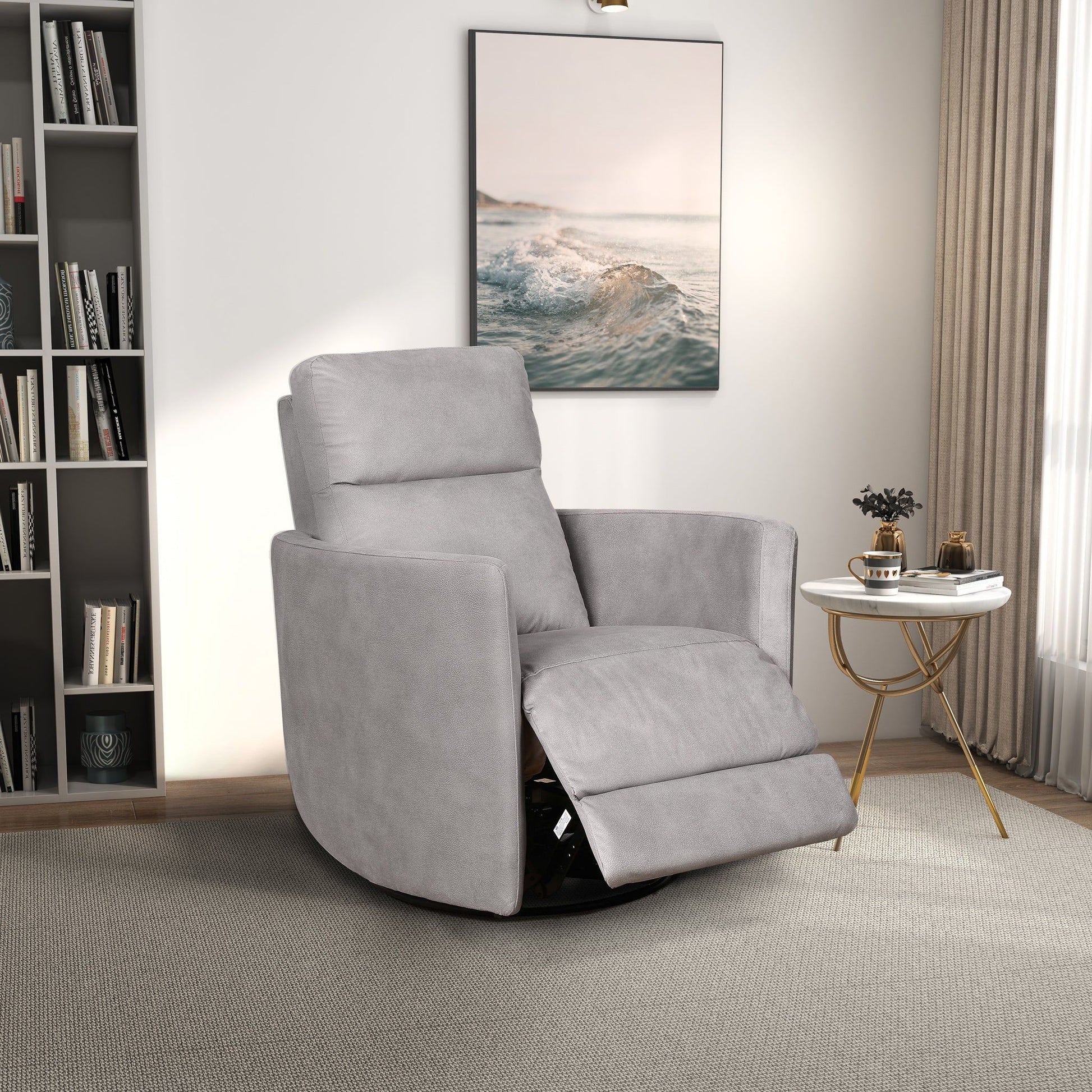 A modern living room featuring the Lawson Swivel Glider Suede Recliner Chair in Latte, a round white side table with gold legs, books, a small plant, bookshelf, large ocean artwork, and natural light streaming through sheer curtains.