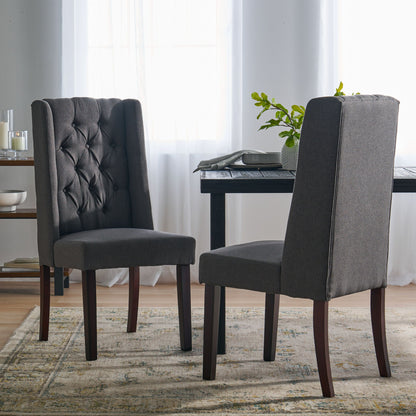 Two Sophisticated Tufted Dining Chairs With High Back Design and wooden legs sit on a patterned rug near a dining table in a bright room with sheer white curtains and abundant natural light.