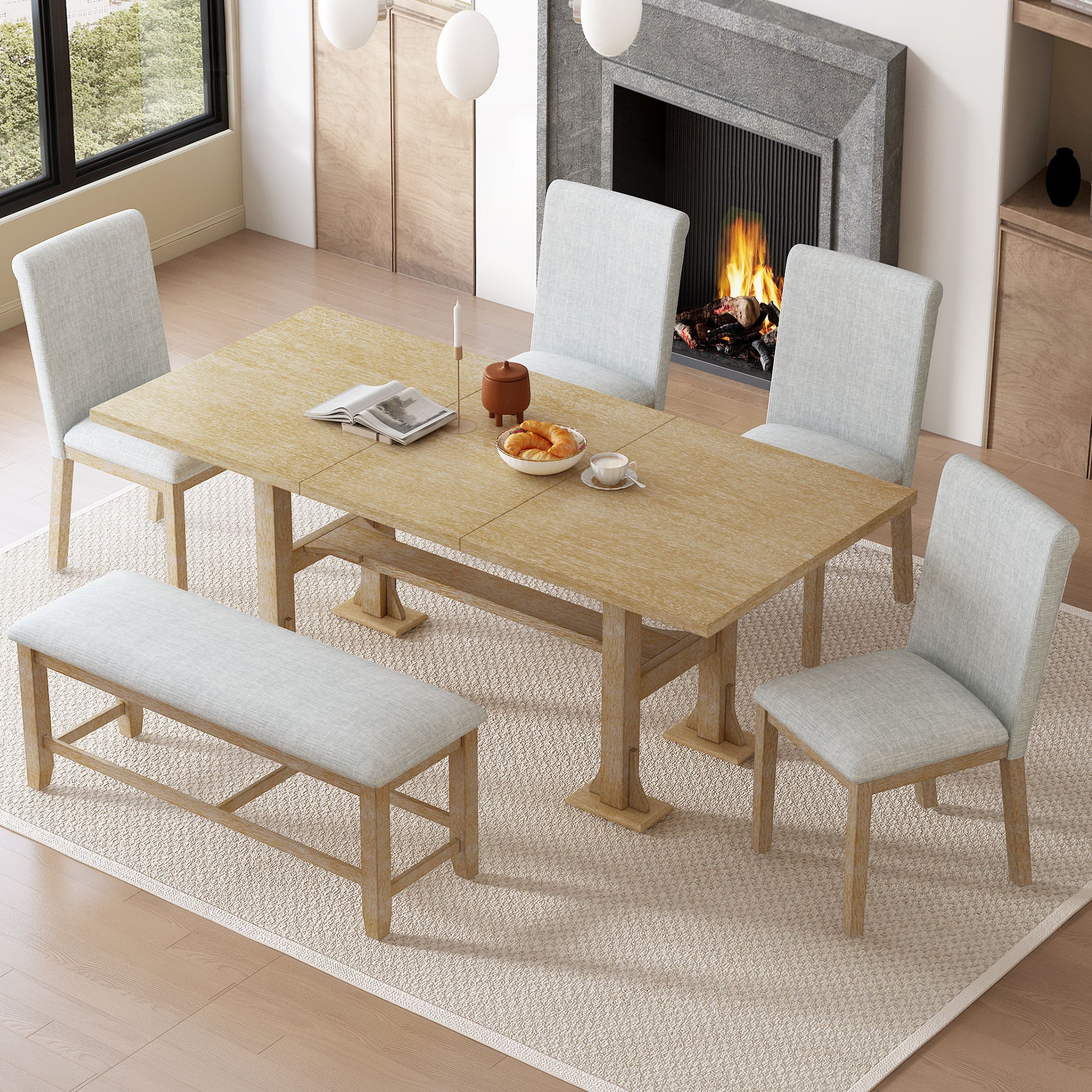 The Topmax 6 Piece Farmhouse Extendable Dining Table Set, with removable leaf, upholstered chairs and bench, sits on a cream rug in a cozy room set for tea by the fireplace and large window.