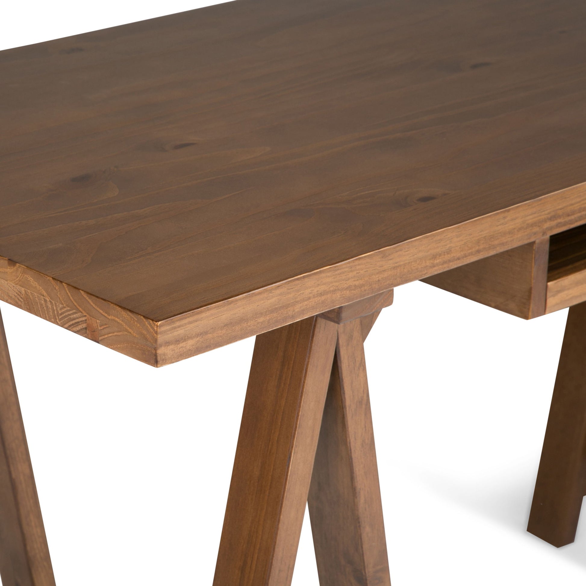 A close-up of the Sawhorse - Handcrafted Desk, featuring a smooth brown finish, angled legs, a rectangular top, and a small horizontal support underneath.